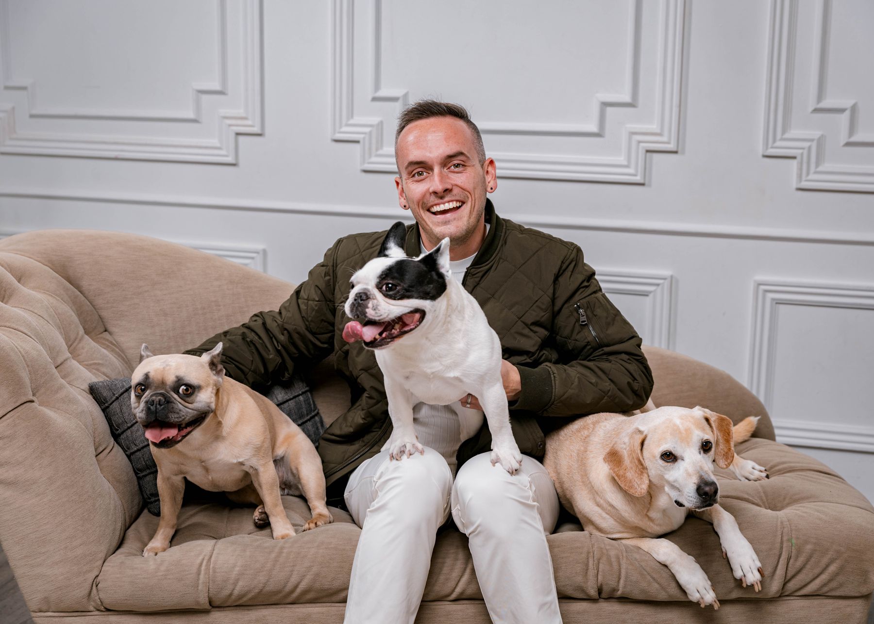 Tyler on a cream sofa with his three dogs